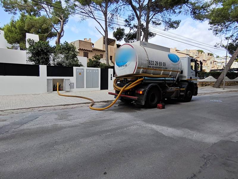 Camión cisterna llenando el aljibe de una vivienda
