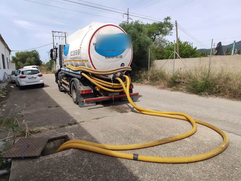 Camió cisterna descarregant aigua amb mànega en un dipòsit